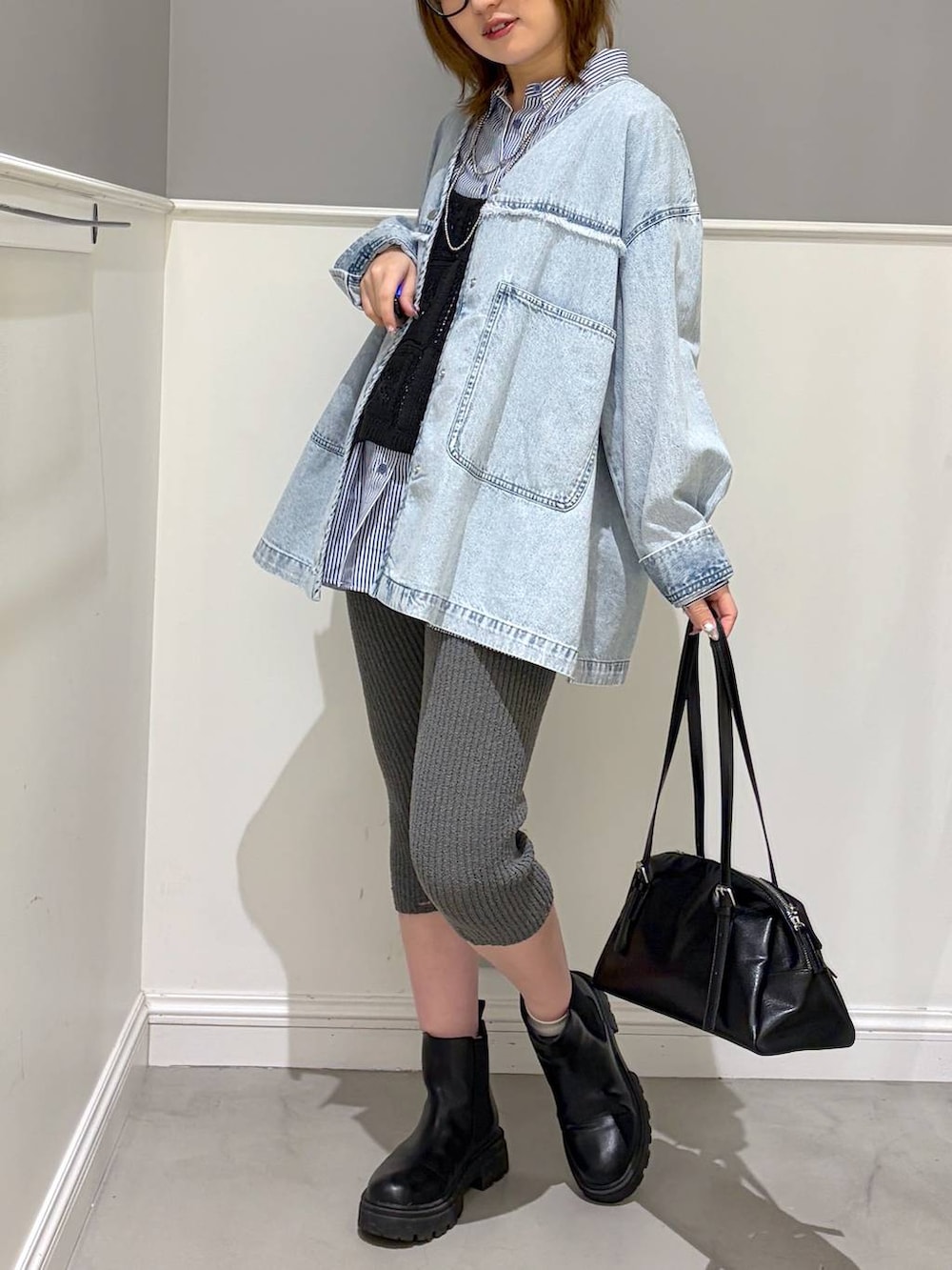 ブラック系のボストンバッグ、ブラック系のブーツ、ブルー系のシャツ/ブラウスを着用したレディースの冬コーディネートの5枚目の写真