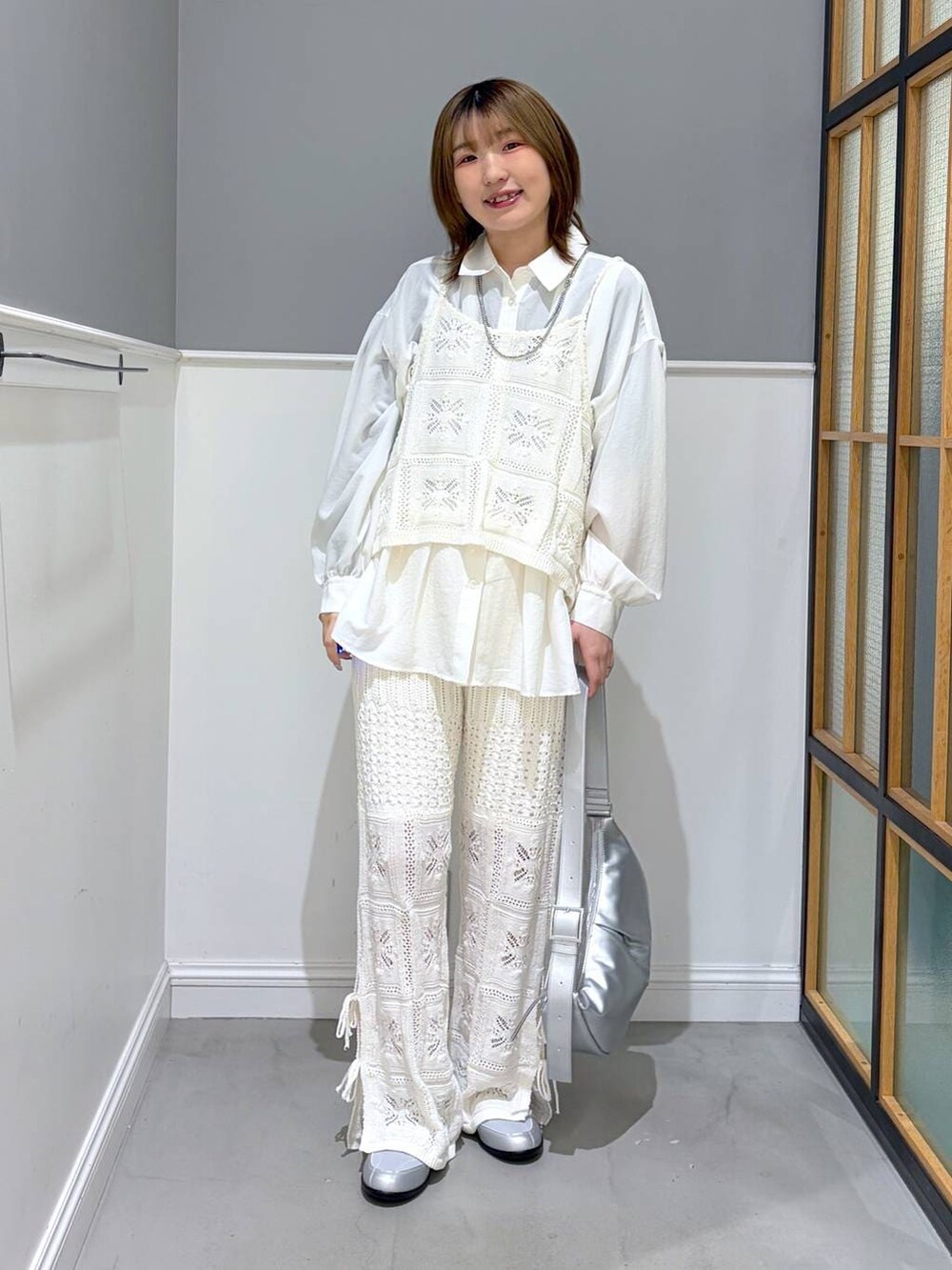 シルバー系のショルダーバッグ、ホワイト系のシャツ/ブラウス、シルバー系のパンプスを着用したレディースの冬コーディネートの4枚目の写真