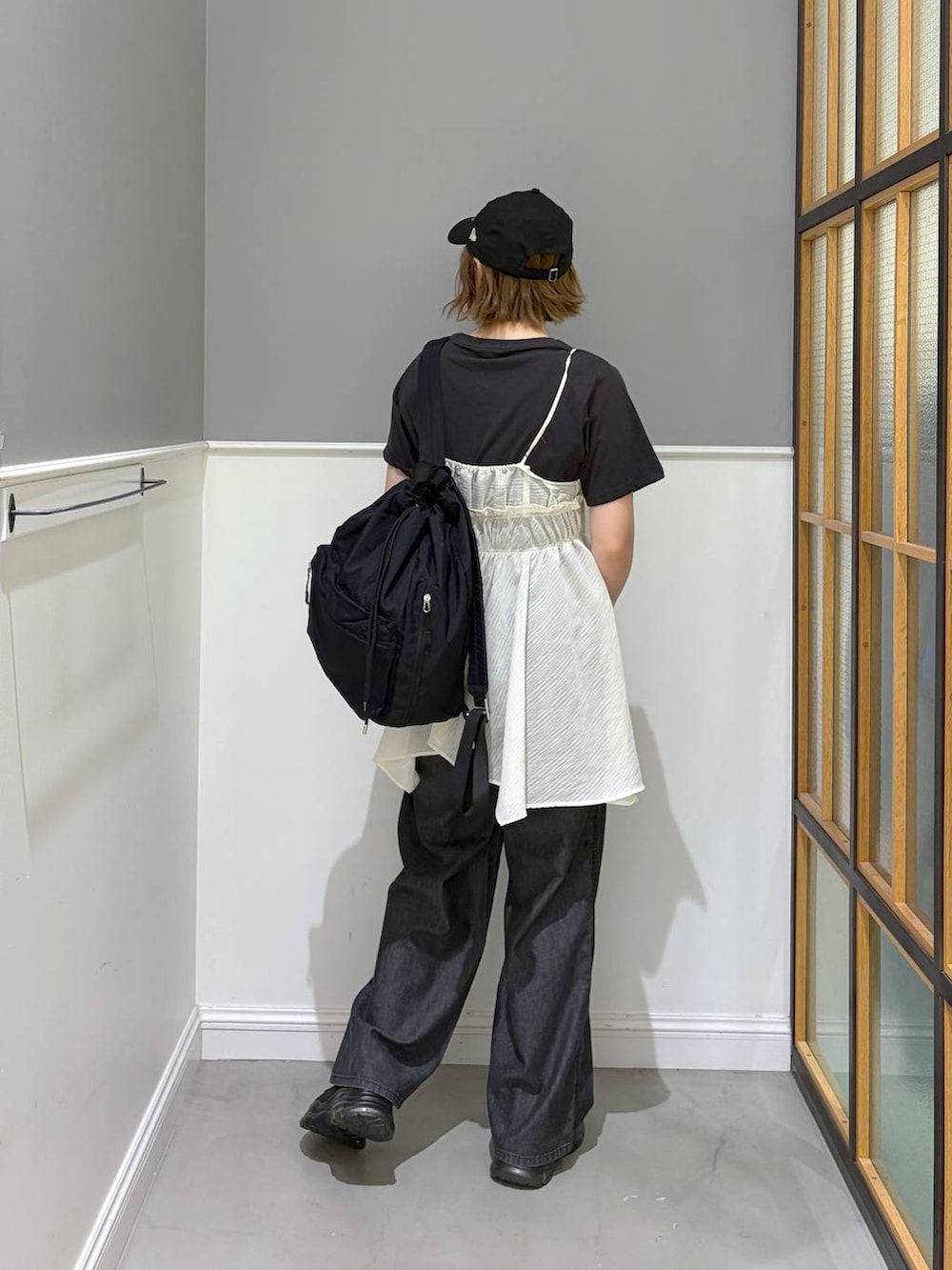 ブラック系のデニムパンツ、ブラック系のバックパック/リュック、ブラック系のスニーカーを着用したレディースの春コーディネートの3枚目の写真