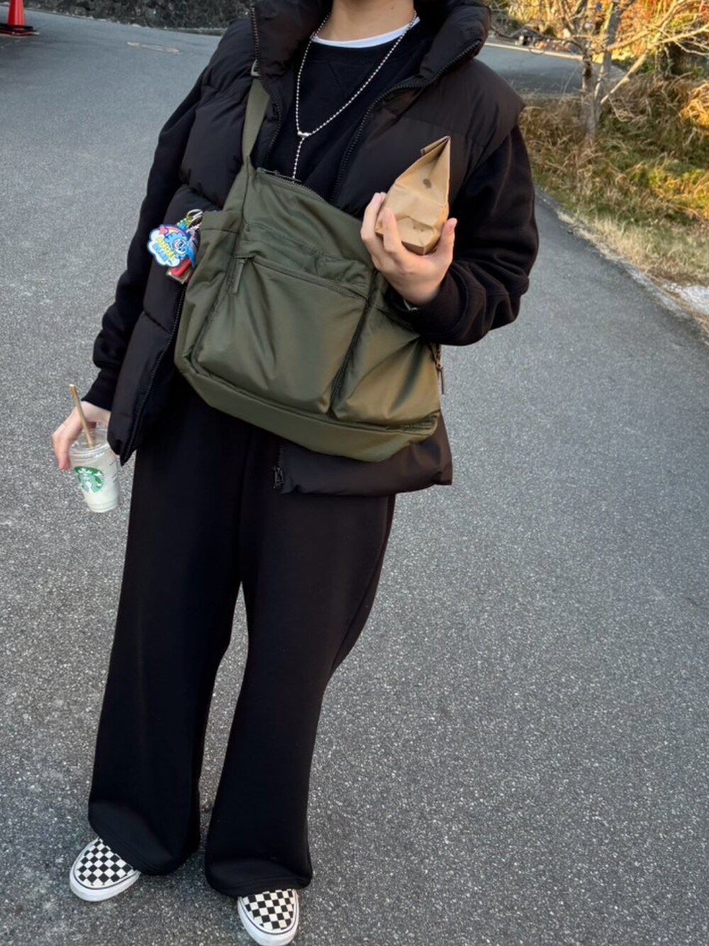 ブラック系のスウェットパンツ、グリーン系のショルダーバッグを着用したレディースの冬コーディネートの2枚目の写真