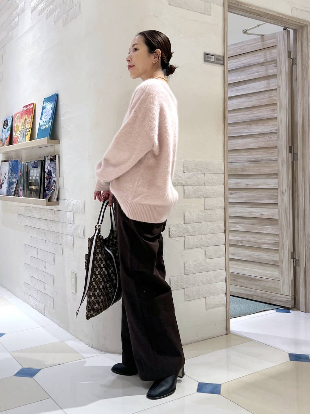ピンク系のニット/セーター、ブラウン系のショルダーバッグ、ブラック系のブーツを着用したレディースの秋コーディネートの3枚目の写真