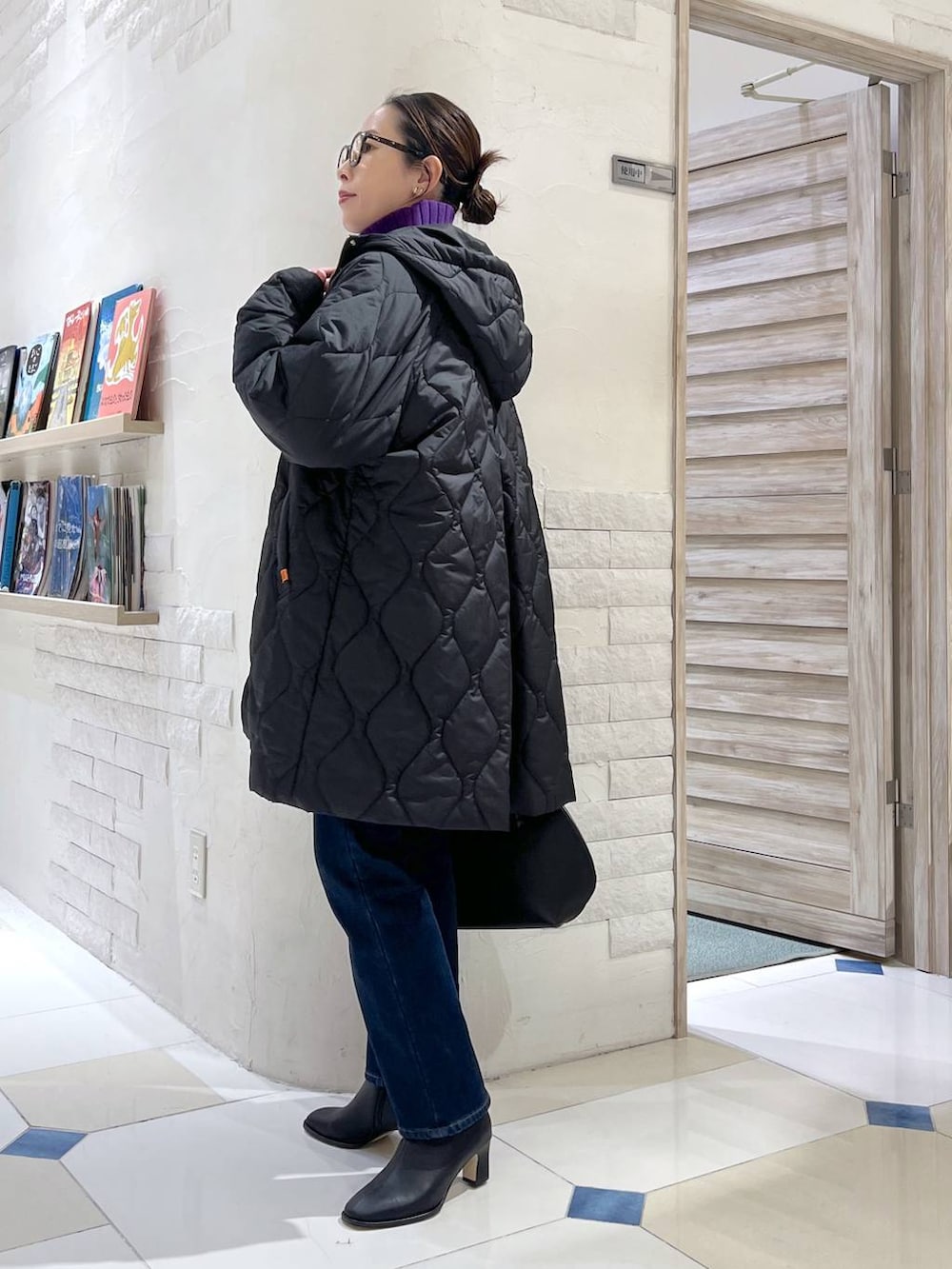 ブラック系のトートバッグ、ブルー系のデニムパンツ、パープル系のニット/セーターを着用したレディースの秋コーディネートの4枚目の写真