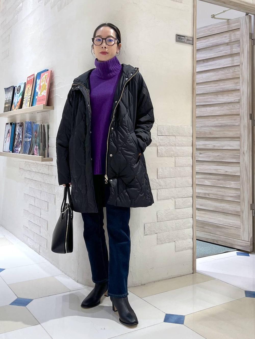 ブラック系のトートバッグ、ブルー系のデニムパンツ、パープル系のニット/セーターを着用したレディースの秋コーディネートの2枚目の写真