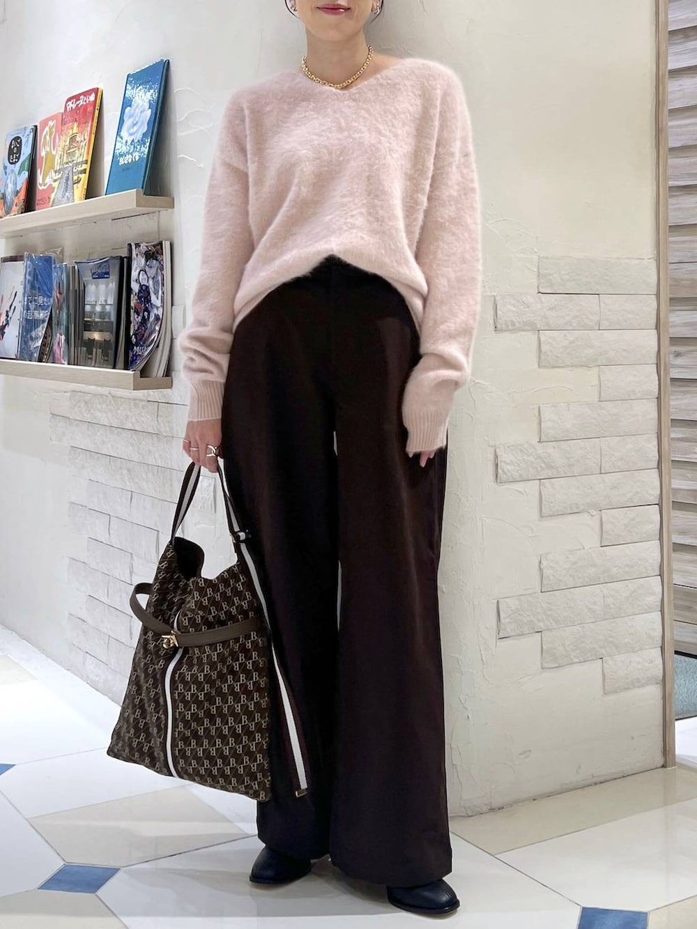 ピンク系のニット/セーター、ブラウン系のショルダーバッグ、ブラック系のブーツを着用したレディースの秋コーディネートの5枚目の写真