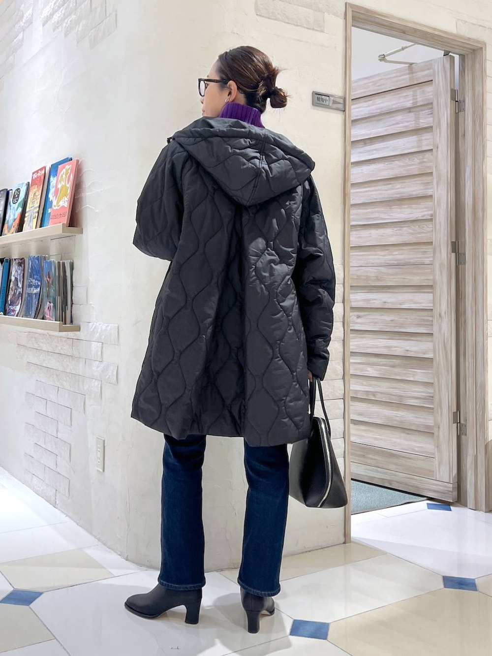 ブラック系のトートバッグ、ブルー系のデニムパンツ、パープル系のニット/セーターを着用したレディースの秋コーディネートの5枚目の写真