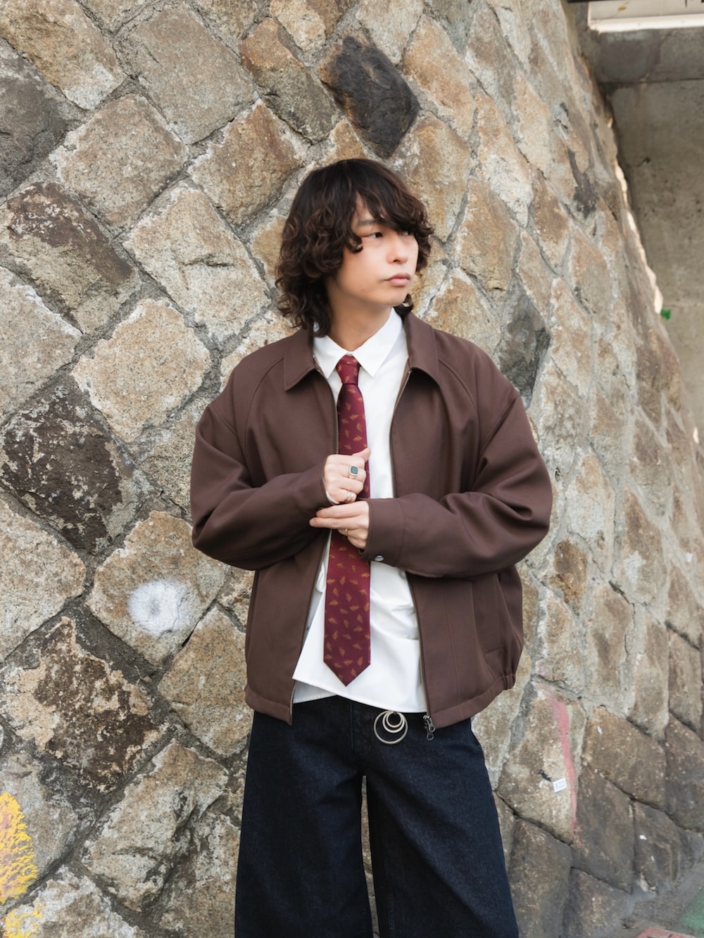 ブラウン系のブルゾン、ホワイト系のシャツ/ブラウス、ブルー系のデニムパンツを着用したメンズの冬コーディネートの6枚目の写真