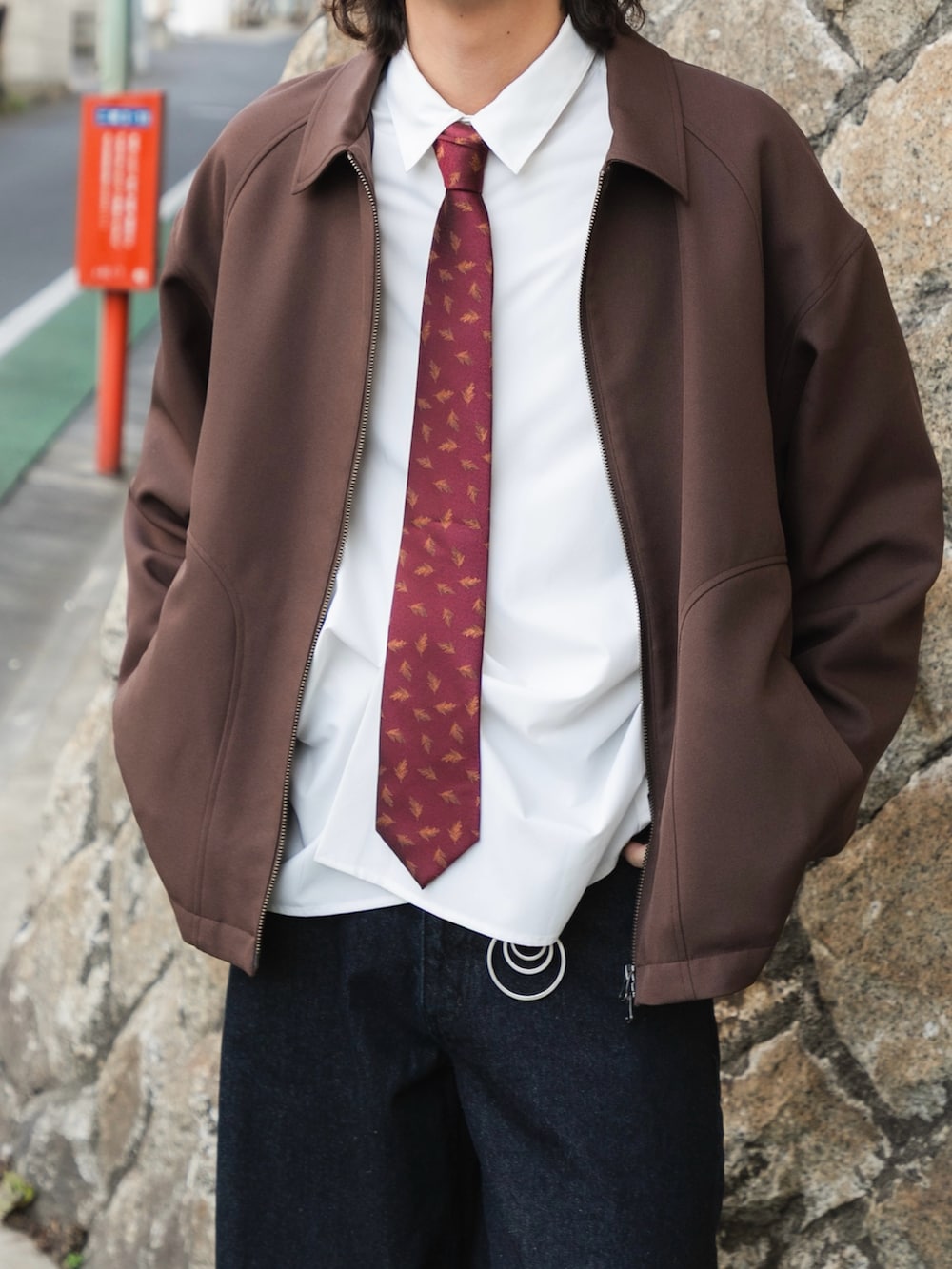 ブラウン系のブルゾン、ホワイト系のシャツ/ブラウス、ブルー系のデニムパンツを着用したメンズの冬コーディネートの2枚目の写真