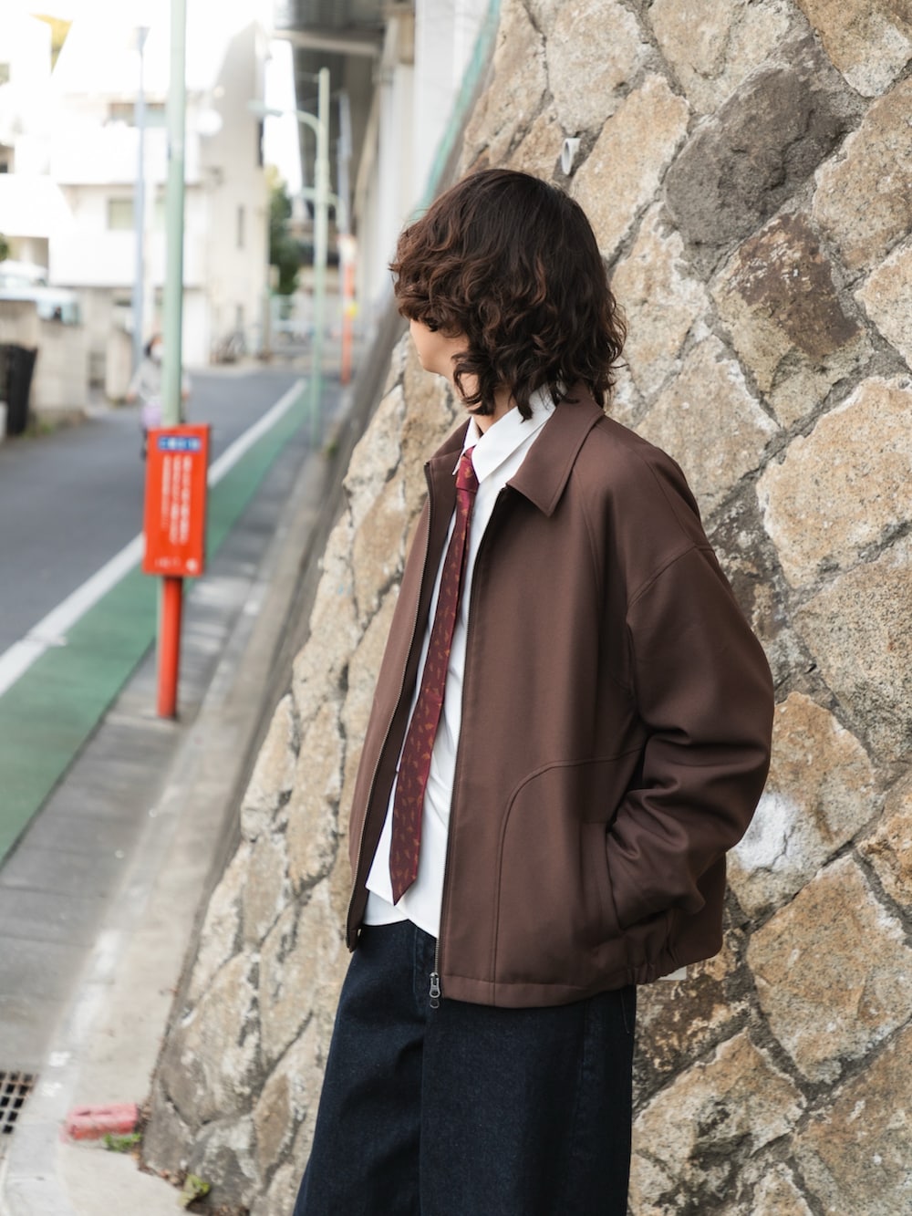 ブラウン系のブルゾン、ホワイト系のシャツ/ブラウス、ブルー系のデニムパンツを着用したメンズの冬コーディネートの5枚目の写真