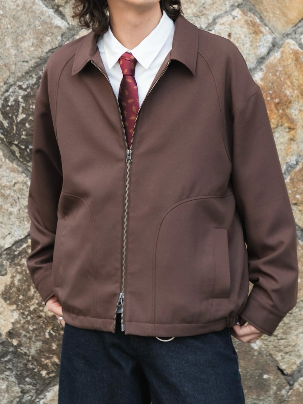 ブラウン系のブルゾン、ホワイト系のシャツ/ブラウス、ブルー系のデニムパンツを着用したメンズの冬コーディネートの3枚目の写真