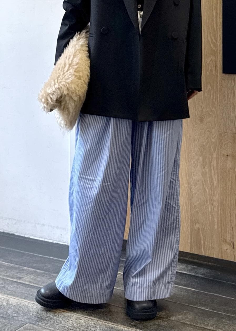 ブルー系のスラックス、ブラック系のテーラードジャケット、ベージュ系のトートバッグを着用したレディースの秋コーディネートの7枚目の写真