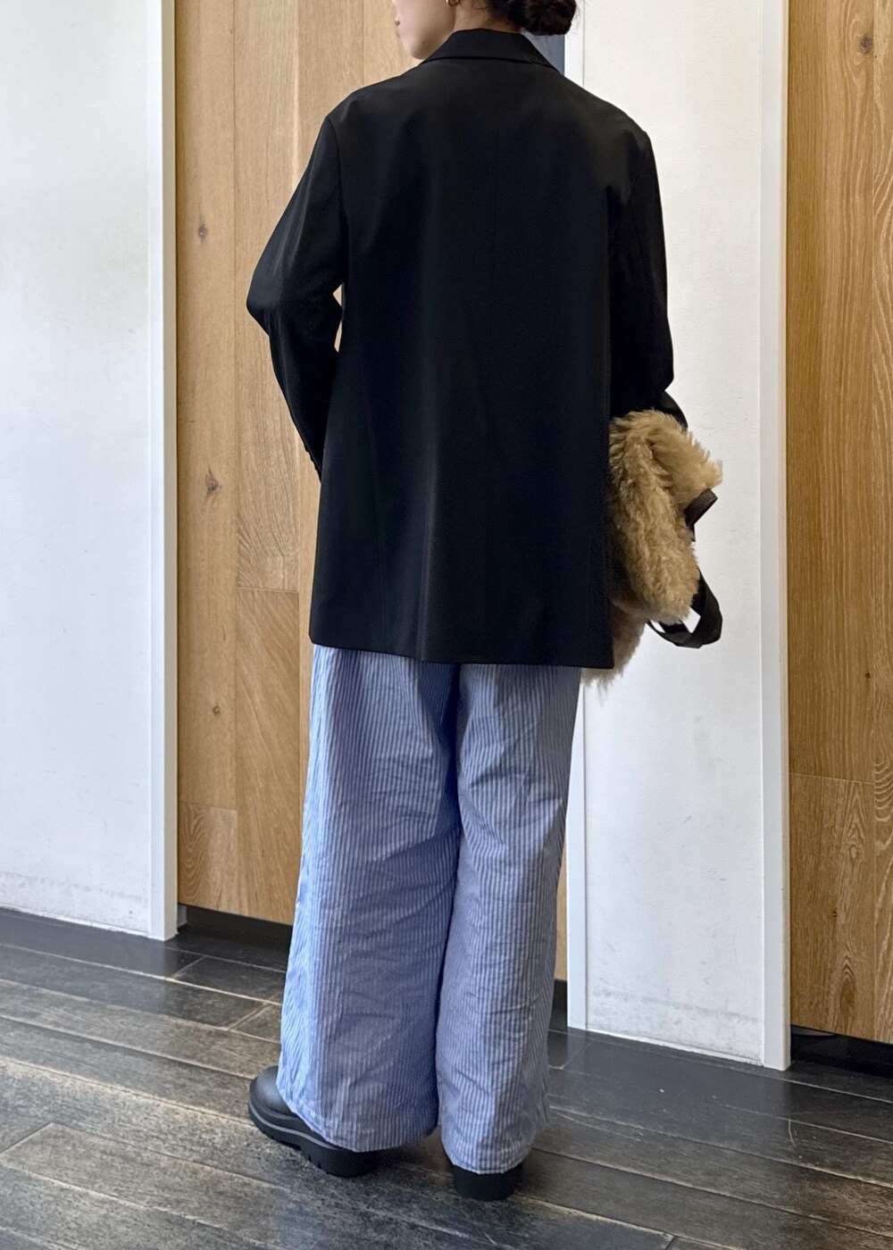 ブルー系のスラックス、ブラック系のテーラードジャケット、ベージュ系のトートバッグを着用したレディースの秋コーディネートの3枚目の写真