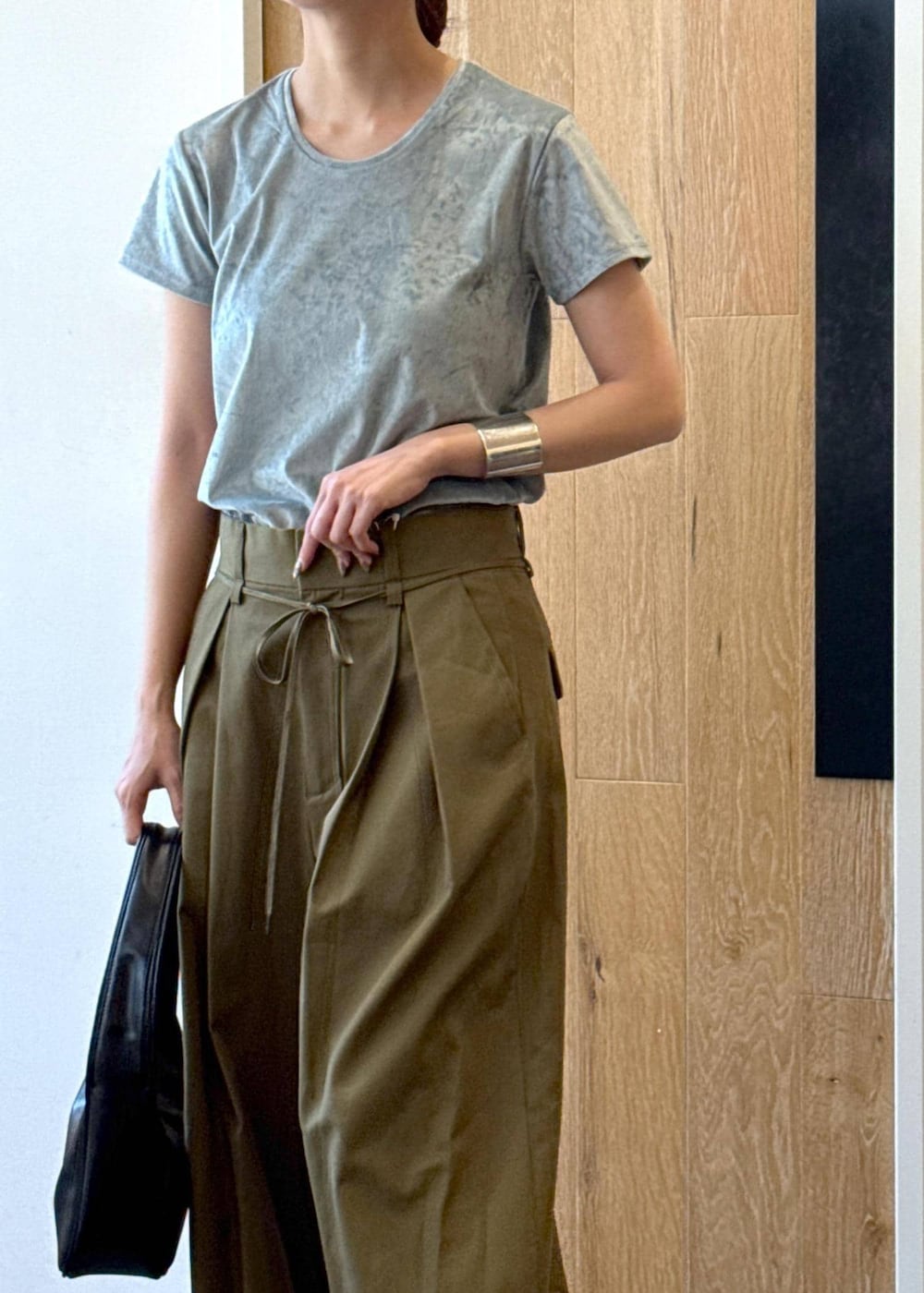 ブラック系のハンドバッグ、ブラック系のサンダル、ブルー系のTシャツ/カットソーを着用したレディースの夏コーディネートの4枚目の写真