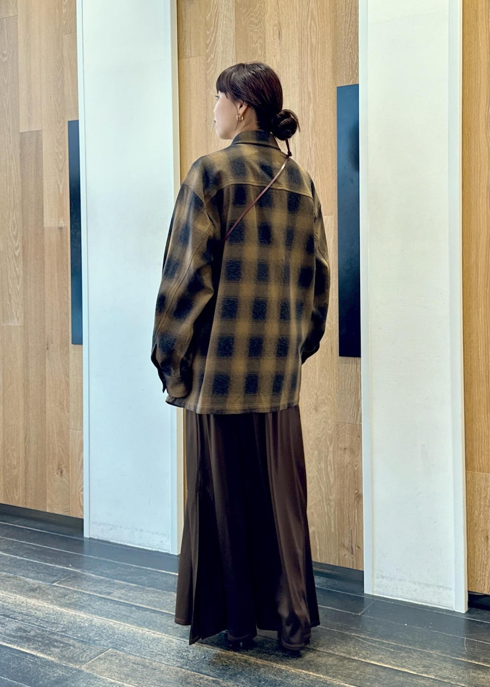 ブラック系のブーツ、ブラウン系のスカート、イエロー系のシャツ/ブラウスを着用したレディースの秋コーディネートの5枚目の写真