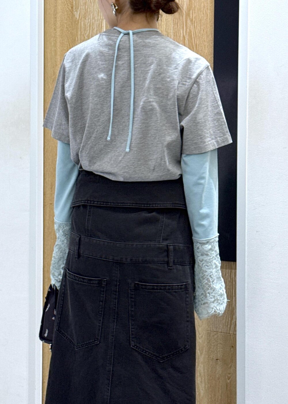 ブラック系のワンピース、ブルー系のTシャツ/カットソー、ブラック系のショルダーバッグを着用したレディースの春コーディネートの5枚目の写真