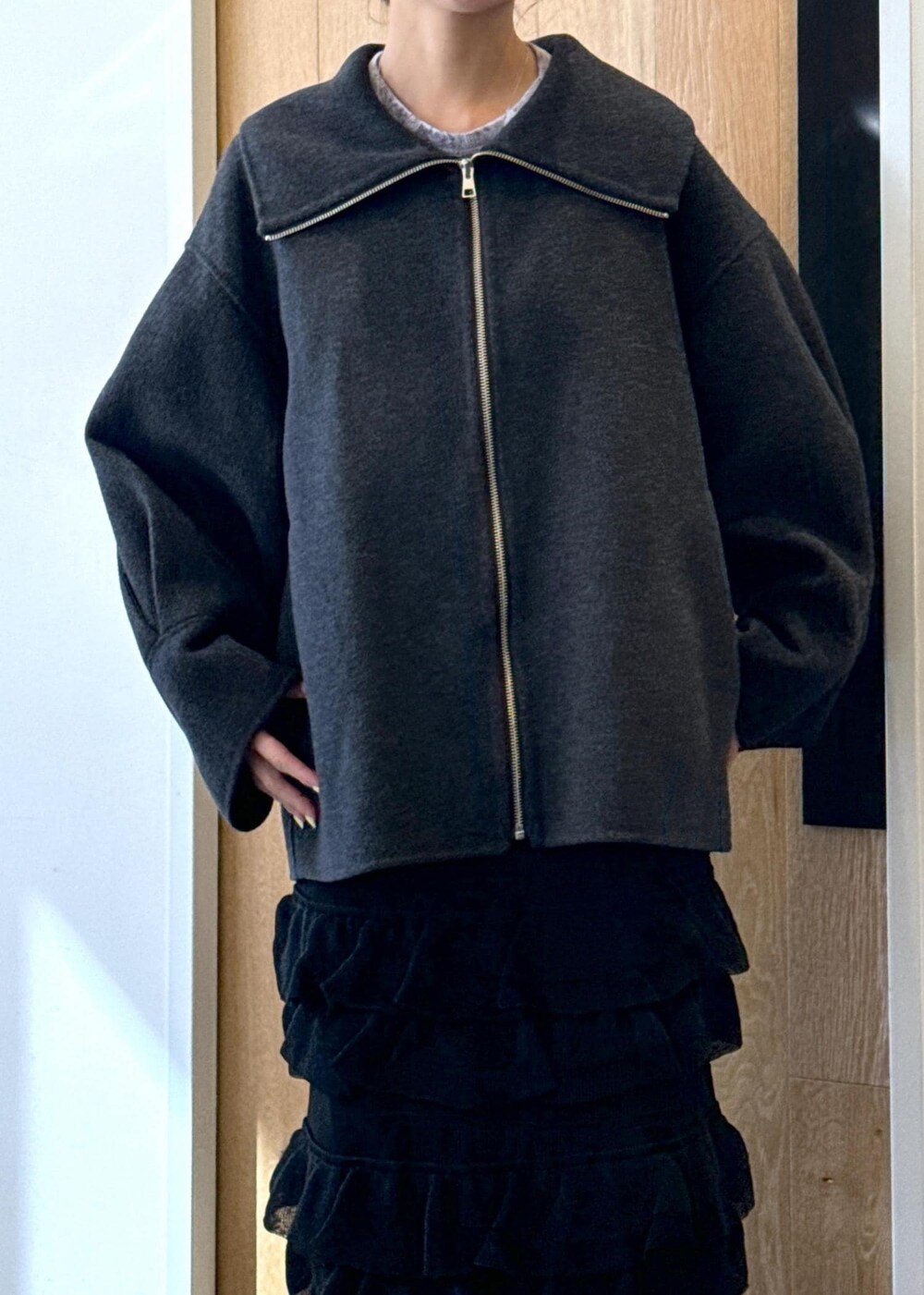 グレー系のTシャツ/カットソー、ブラック系のサンダル、ブラック系のスカートを着用したレディースの秋コーディネートの8枚目の写真