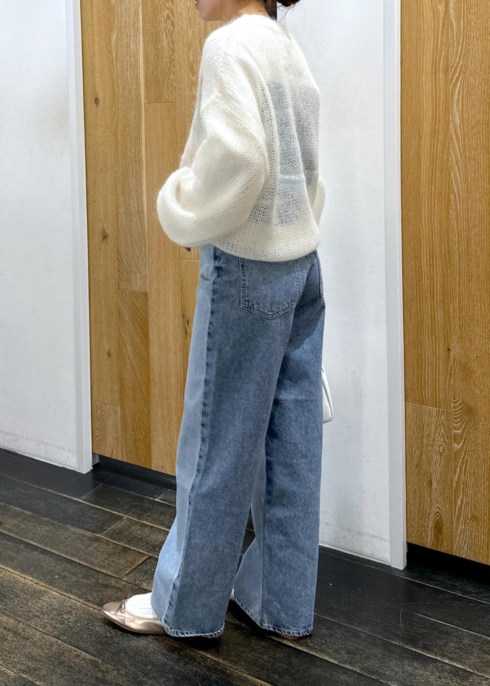 ホワイト系のニット/セーター、ホワイト系のボストンバッグ、ホワイト系のTシャツ/カットソーを着用したレディースの冬コーディネートの2枚目の写真