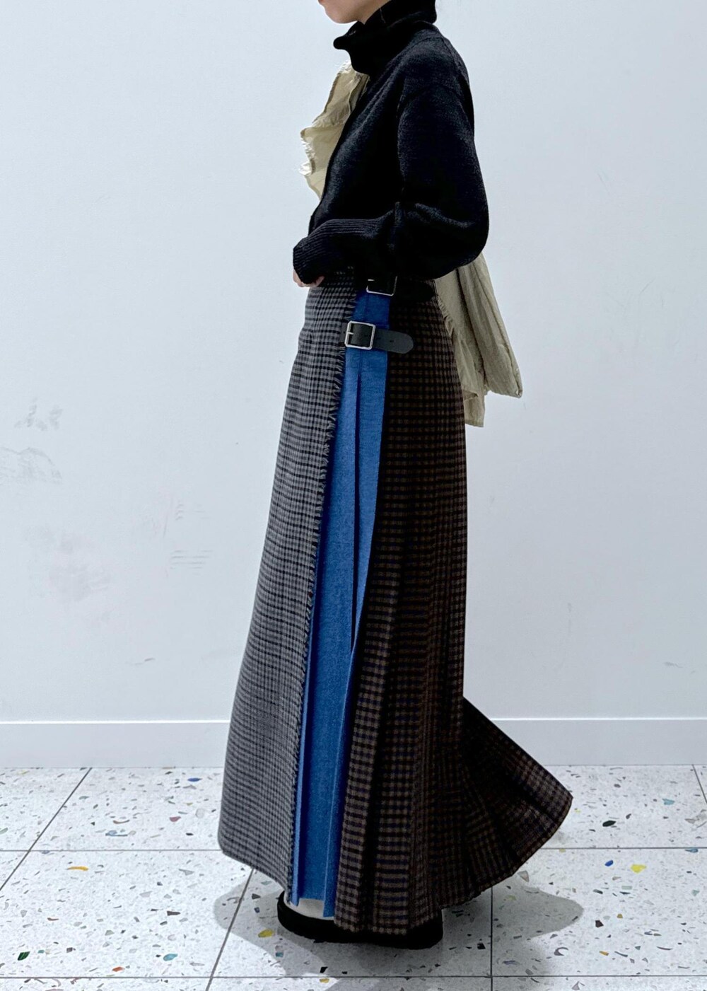 グレー系のスカート、ホワイト系のブーツ、グレー系のカーディガン/ボレロを着用したレディースの秋コーディネートの3枚目の写真