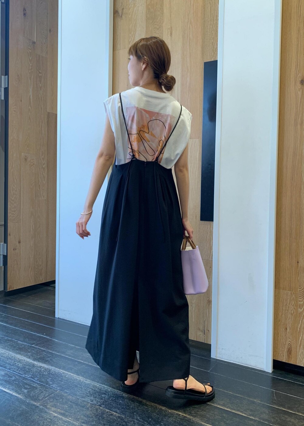 ブラック系のサンダル、ブラック系のワンピース、パープル系のショルダーバッグを着用したレディースの夏コーディネートの3枚目の写真