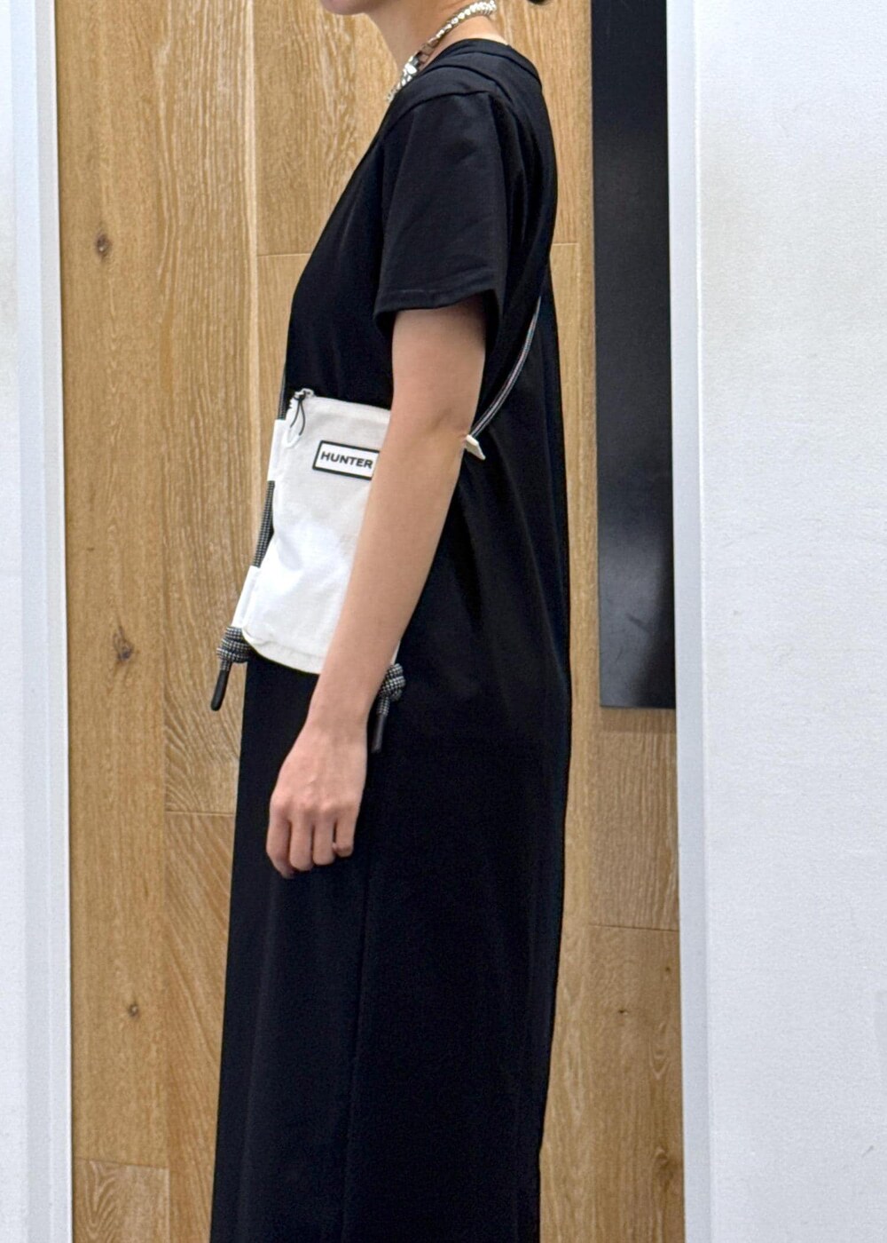 ブラック系のパンプス、ホワイト系のボディバッグ/ウエストポーチ、ブラック系のワンピースを着用したレディースの夏コーディネートの5枚目の写真