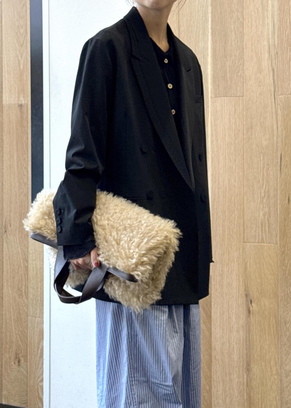 ブルー系のスラックス、ブラック系のテーラードジャケット、ベージュ系のトートバッグを着用したレディースの秋コーディネートの5枚目の写真