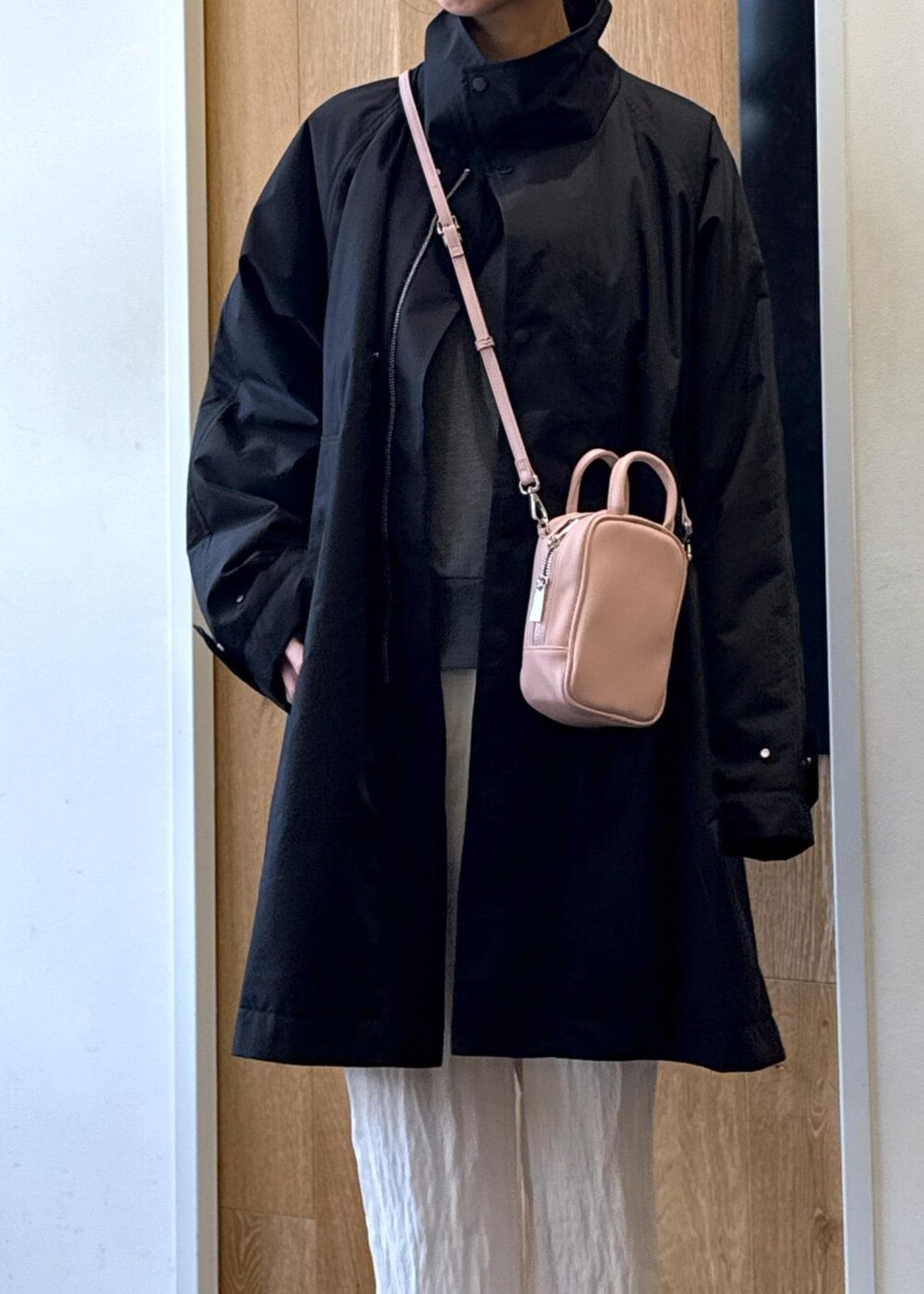 ピンク系のショルダーバッグ、ホワイト系のサンダル、ブラック系のスウェットを着用したレディースの冬コーディネートの5枚目の写真