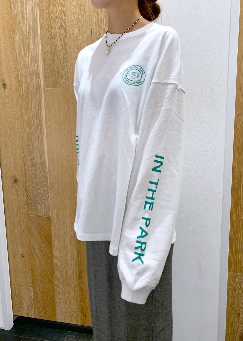 ブラック系のスカート、ホワイト系のTシャツ/カットソー、ブラック系のネックレスを着用したレディースの夏コーディネートの4枚目の写真