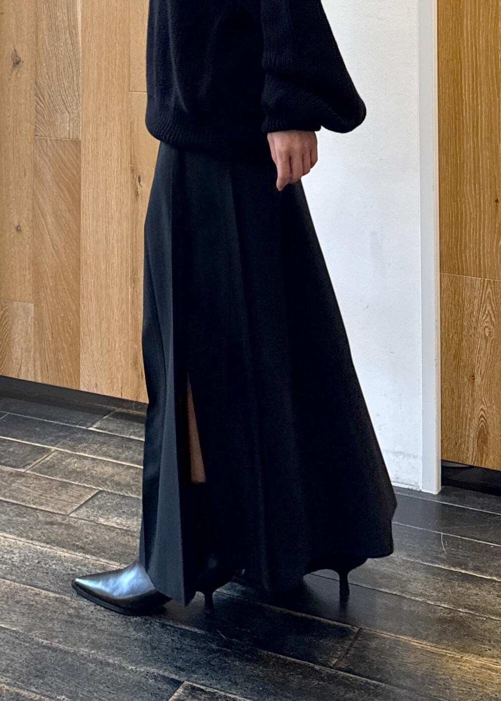 ブラック系のショルダーバッグ、ブラック系のスカート、ブラック系のブーツを着用したレディースの秋コーディネートの8枚目の写真