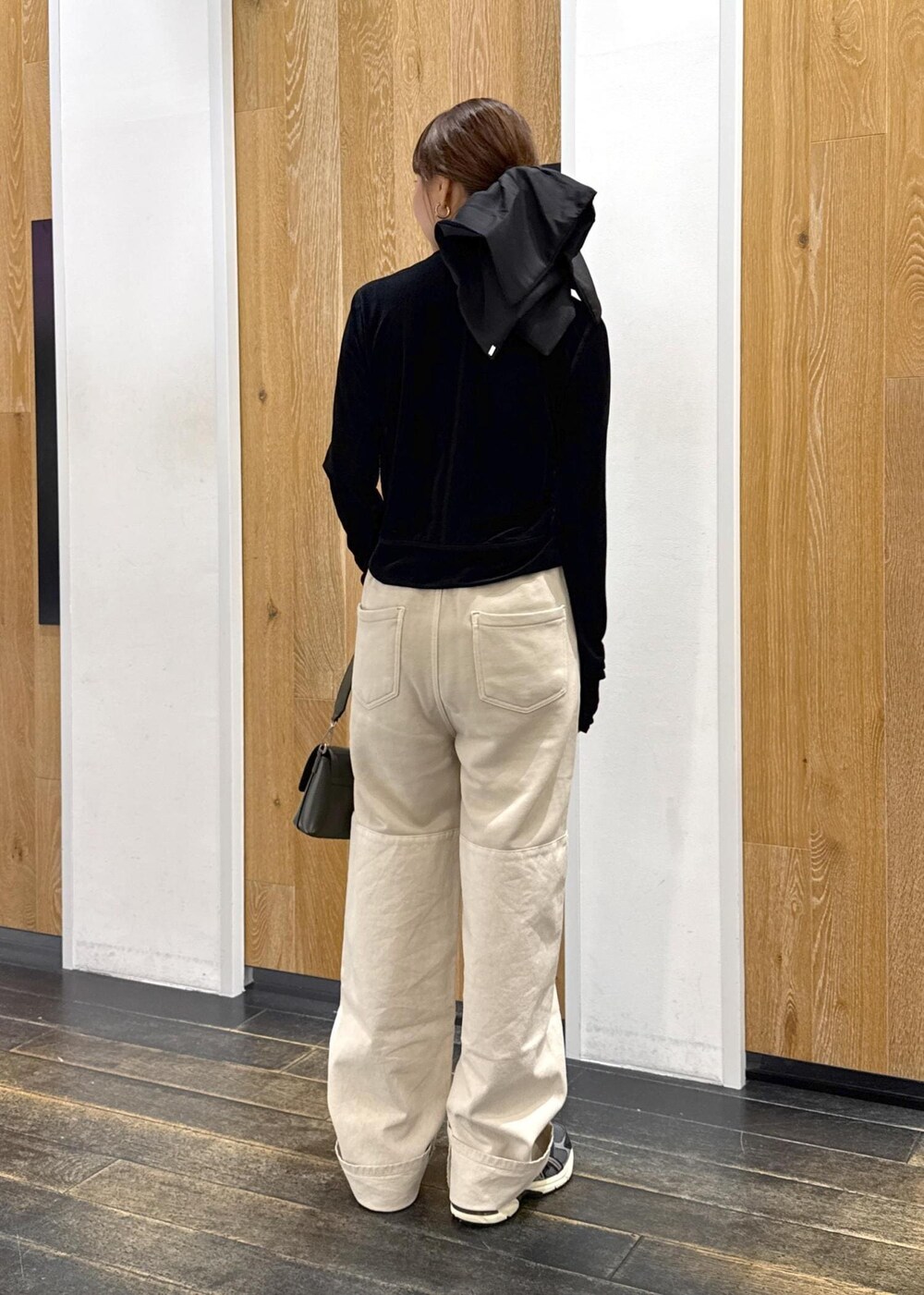 ブラック系のチューブトップ、グリーン系のショルダーバッグ、ブラック系のカーディガン/ボレロを着用したレディースの秋コーディネートの3枚目の写真