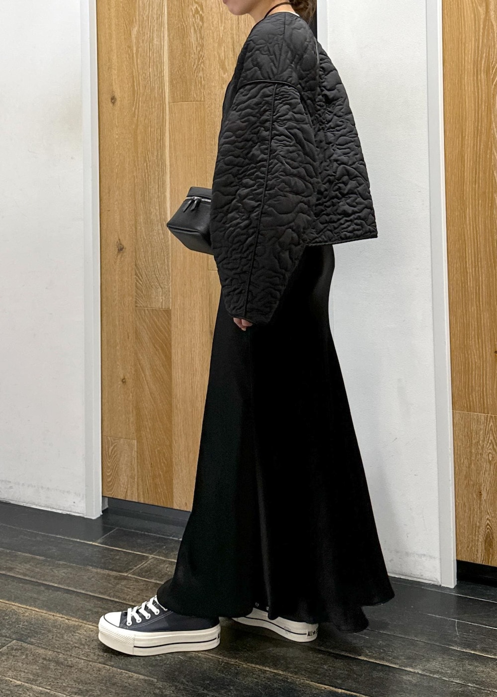 ホワイト系のスウェット、ブラック系のスカート、ブラック系のブルゾンを着用したレディースの冬コーディネートの2枚目の写真