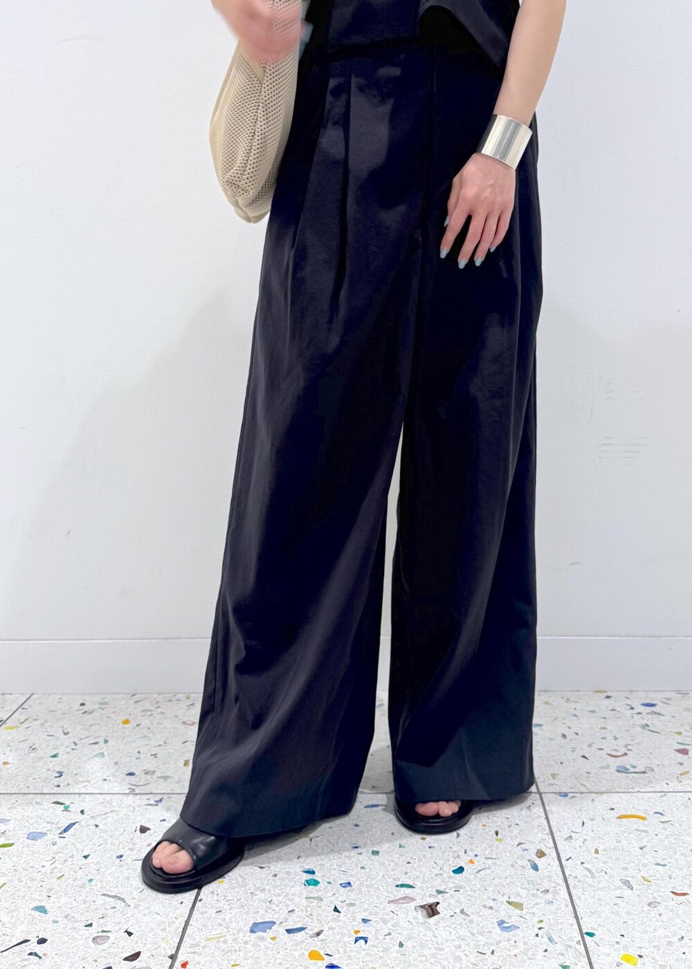 ベージュ系のショルダーバッグ、ブラック系のサンダル、ブラック系のその他パンツを着用したレディースの春コーディネートの7枚目の写真