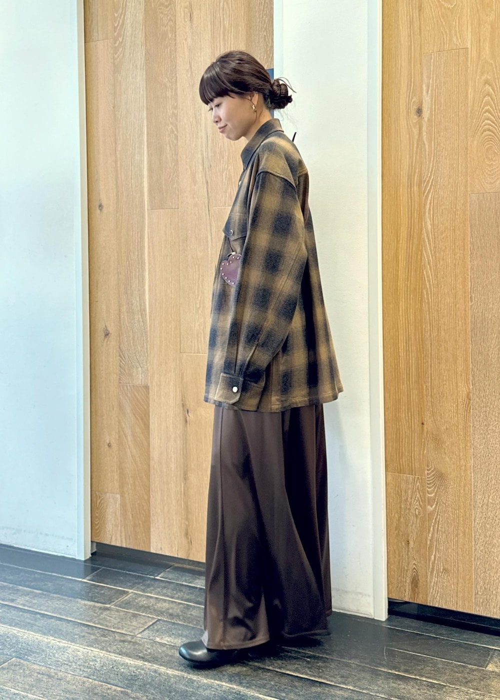 ブラック系のブーツ、ブラウン系のスカート、イエロー系のシャツ/ブラウスを着用したレディースの秋コーディネートの4枚目の写真