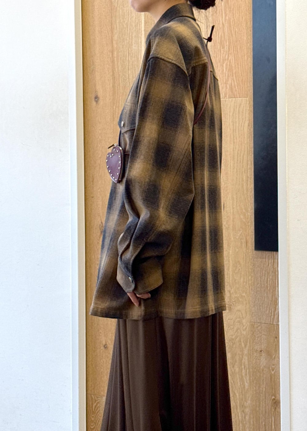 ブラック系のブーツ、ブラウン系のスカート、イエロー系のシャツ/ブラウスを着用したレディースの秋コーディネートの7枚目の写真