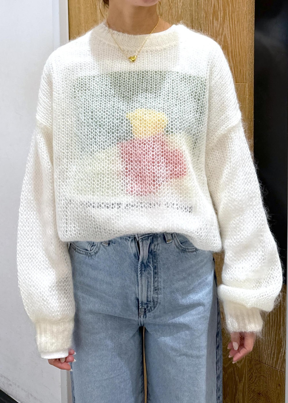 ホワイト系のニット/セーター、ホワイト系のボストンバッグ、ホワイト系のTシャツ/カットソーを着用したレディースの冬コーディネートの4枚目の写真