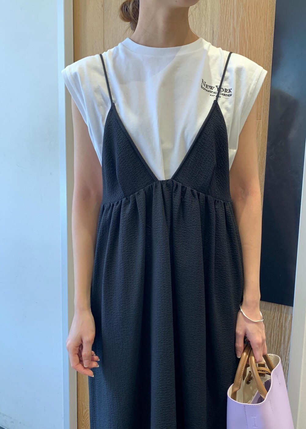 ブラック系のサンダル、ブラック系のワンピース、パープル系のショルダーバッグを着用したレディースの夏コーディネートの4枚目の写真