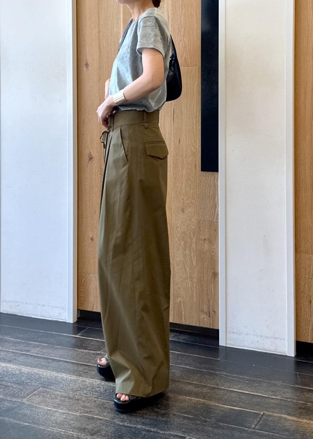 ブラック系のハンドバッグ、ブラック系のサンダル、ブルー系のTシャツ/カットソーを着用したレディースの夏コーディネートの2枚目の写真