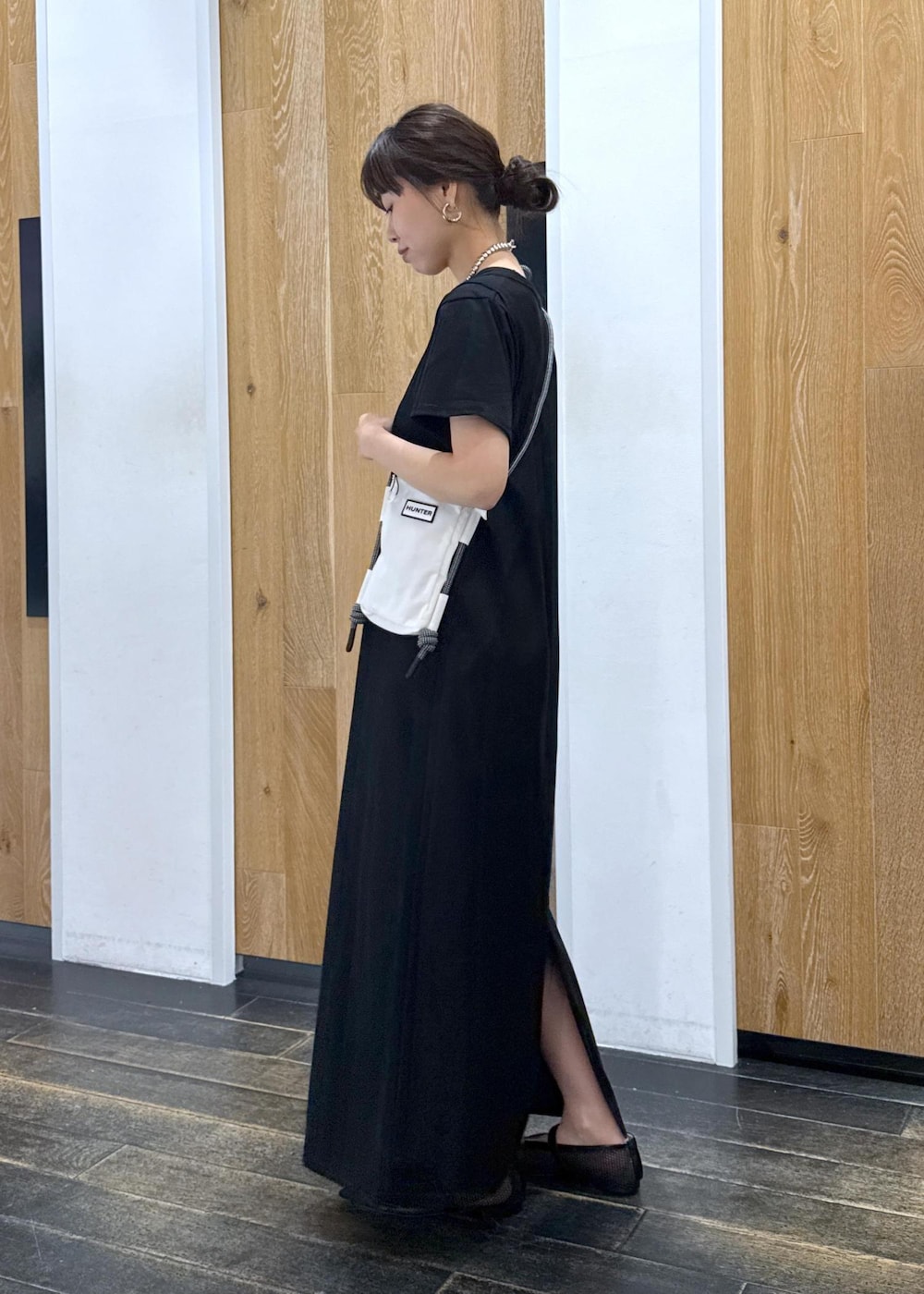 ブラック系のパンプス、ホワイト系のボディバッグ/ウエストポーチ、ブラック系のワンピースを着用したレディースの夏コーディネートの2枚目の写真