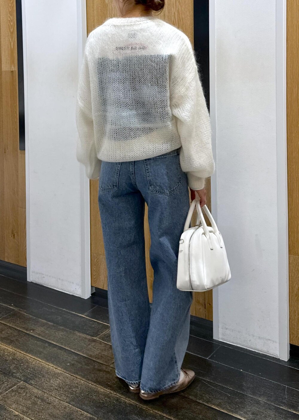 ホワイト系のニット/セーター、ホワイト系のボストンバッグ、ホワイト系のTシャツ/カットソーを着用したレディースの冬コーディネートの3枚目の写真