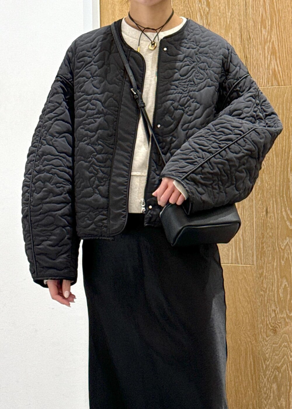 ホワイト系のスウェット、ブラック系のスカート、ブラック系のブルゾンを着用したレディースの冬コーディネートの4枚目の写真