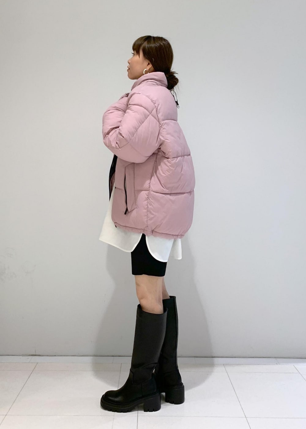 ブラック系のブーツ、ピンク系のダウンジャケット/コート、ブラック系のその他パンツを着用したレディースの秋コーディネートの3枚目の写真