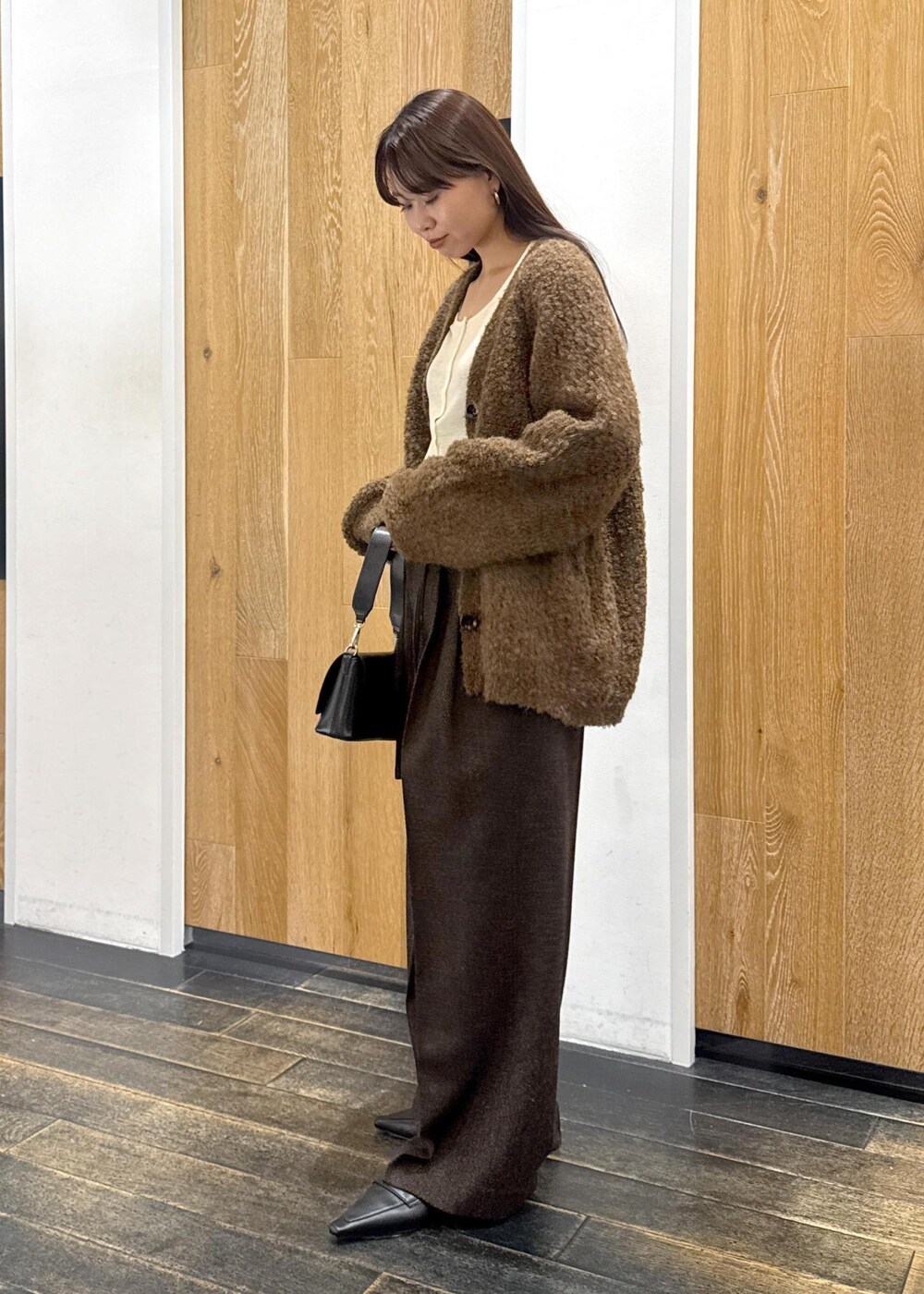 ブラック系のサンダル、ブラック系のショルダーバッグ、ホワイト系のTシャツ/カットソーを着用したレディースの秋コーディネートの3枚目の写真