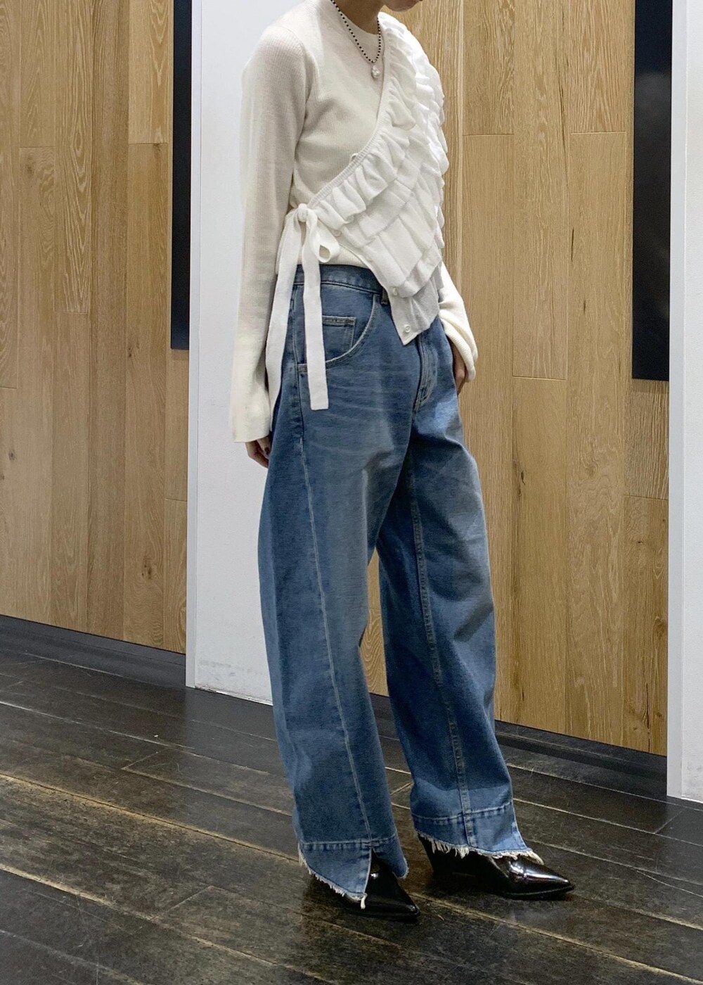 ブラック系のパンプス、ホワイト系のニット/セーター、ブラウン系のトートバッグを着用したレディースの冬コーディネートの2枚目の写真