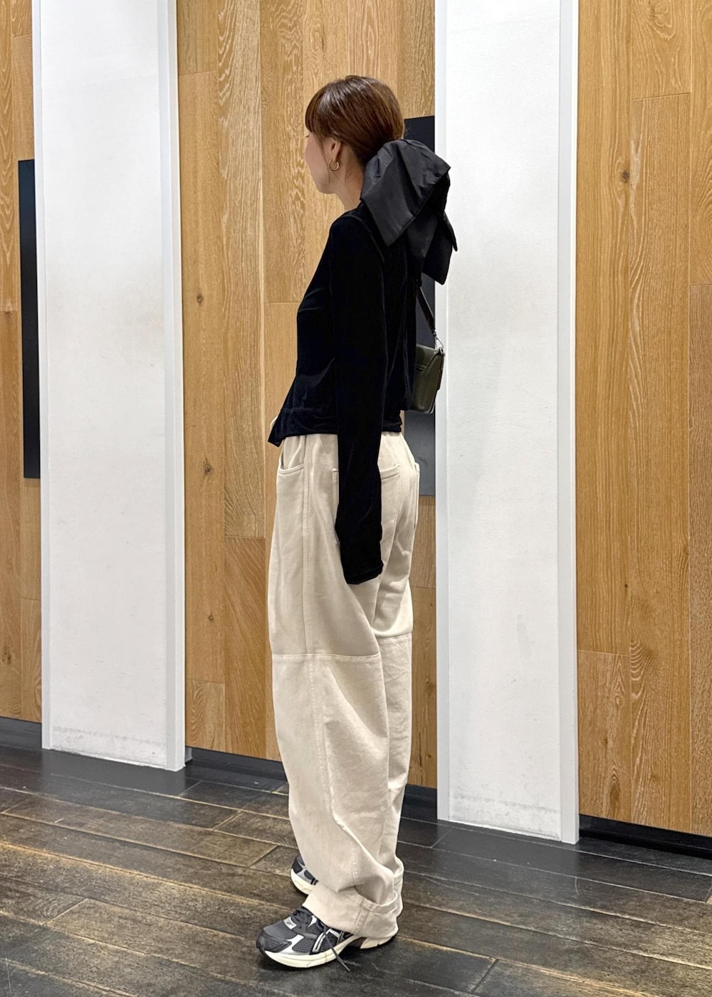 ブラック系のチューブトップ、グリーン系のショルダーバッグ、ブラック系のカーディガン/ボレロを着用したレディースの秋コーディネートの2枚目の写真