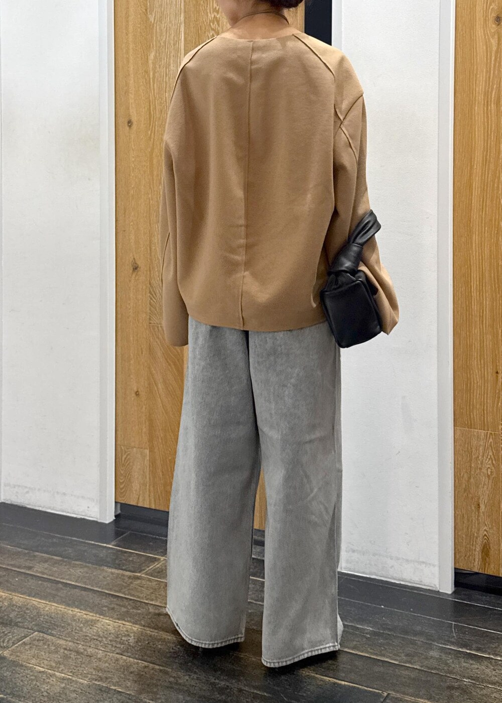 ブラウン系のブーツ、ベージュ系のTシャツ/カットソー、ブルー系のデニムパンツを着用したレディースの秋コーディネートの4枚目の写真