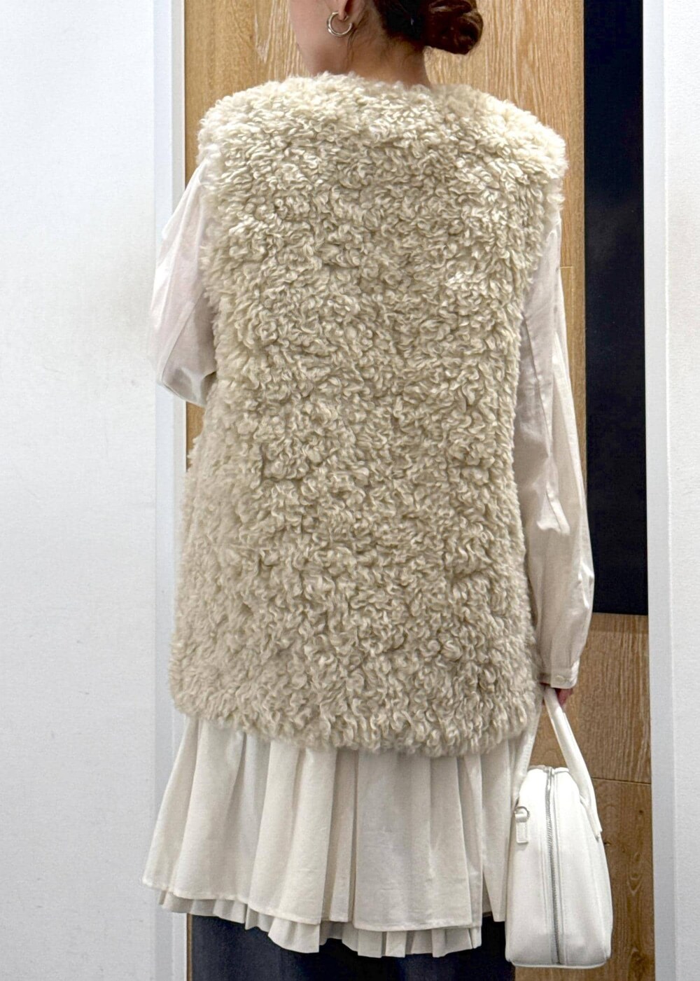 ベージュ系のその他アウター、ホワイト系のボストンバッグ、グレー系のスラックスを着用したレディースの冬コーディネートの7枚目の写真