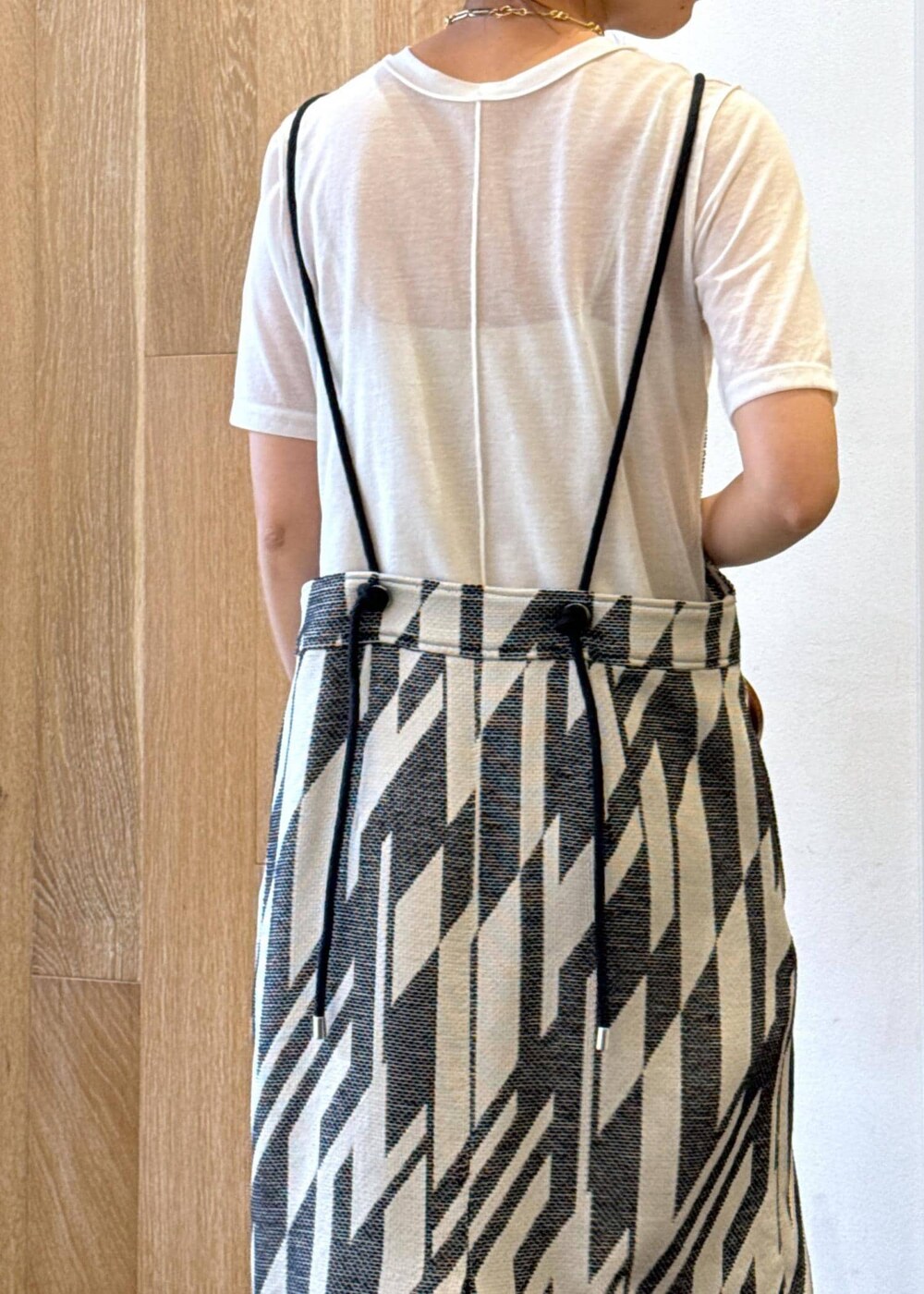 ゴールド系のサンダル、ホワイト系のTシャツ/カットソー、ブラック系のワンピースを着用したレディースの春コーディネートの6枚目の写真
