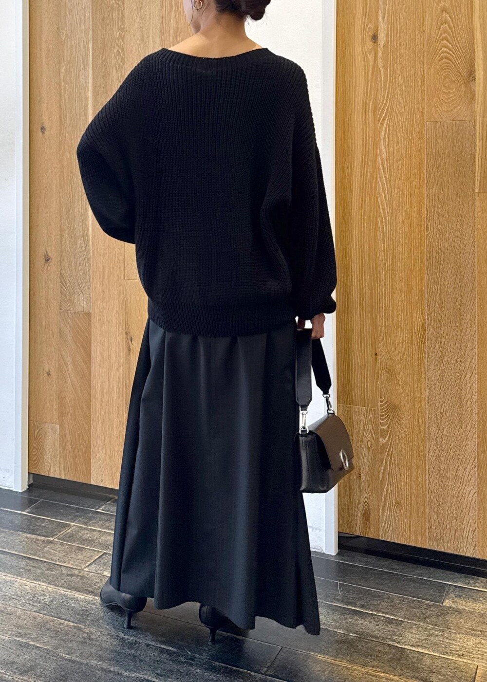 ブラック系のショルダーバッグ、ブラック系のスカート、ブラック系のブーツを着用したレディースの秋コーディネートの4枚目の写真