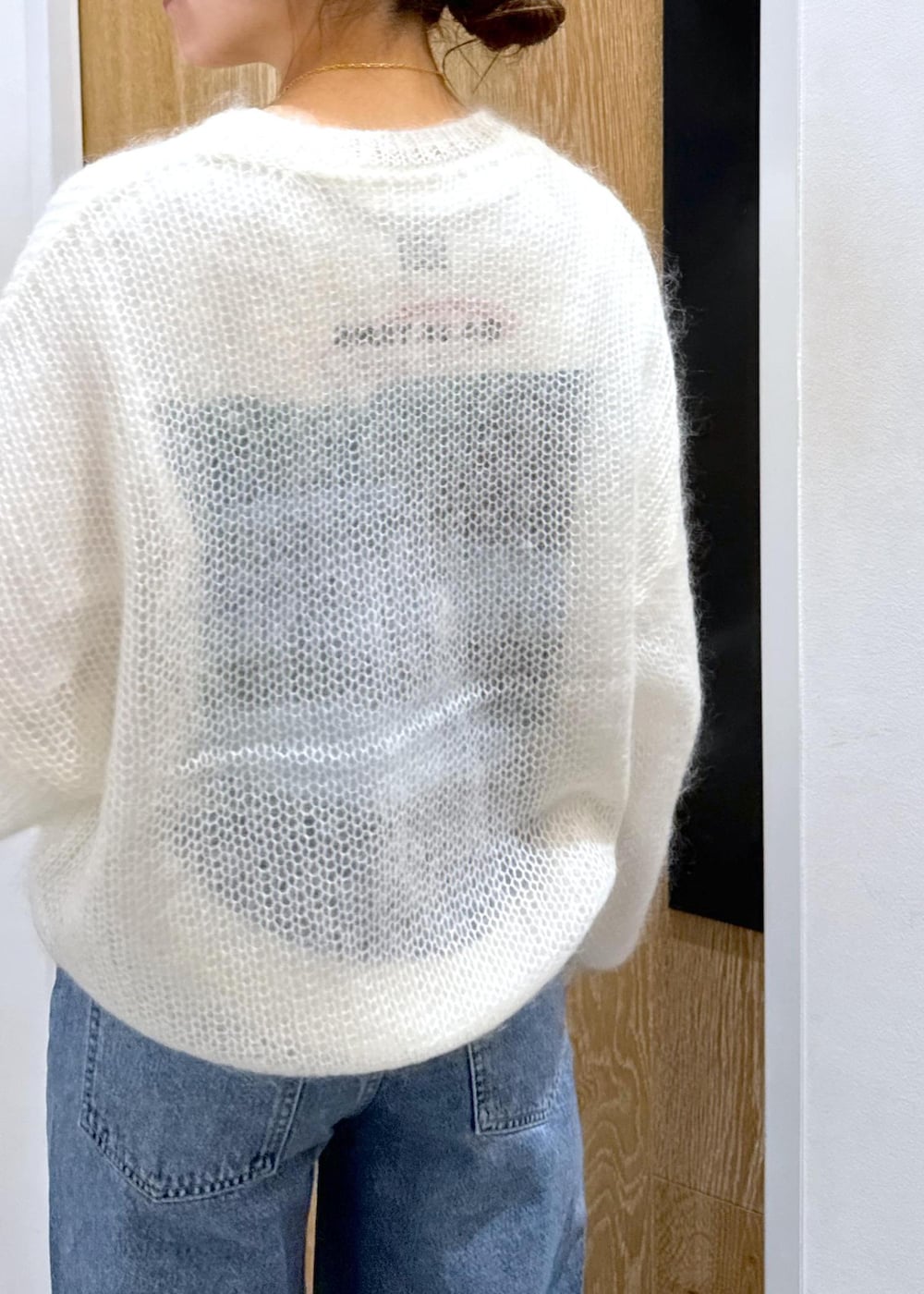 ホワイト系のニット/セーター、ホワイト系のボストンバッグ、ホワイト系のTシャツ/カットソーを着用したレディースの冬コーディネートの6枚目の写真