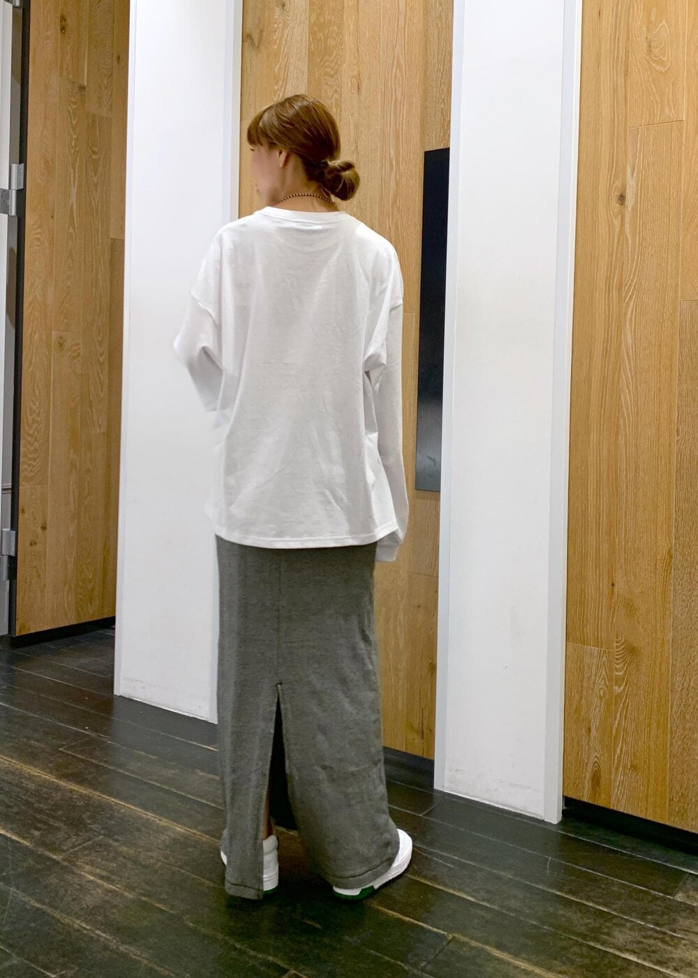 ブラック系のスカート、ホワイト系のTシャツ/カットソー、ブラック系のネックレスを着用したレディースの夏コーディネートの3枚目の写真