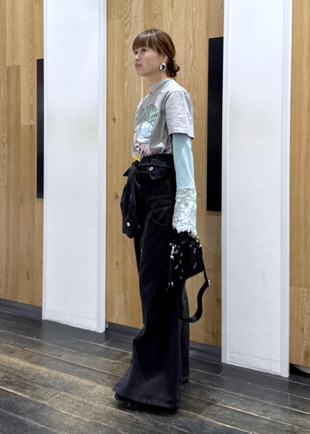 ブラック系のワンピース、ブルー系のTシャツ/カットソー、ブラック系のショルダーバッグを着用したレディースの春コーディネートの2枚目の写真