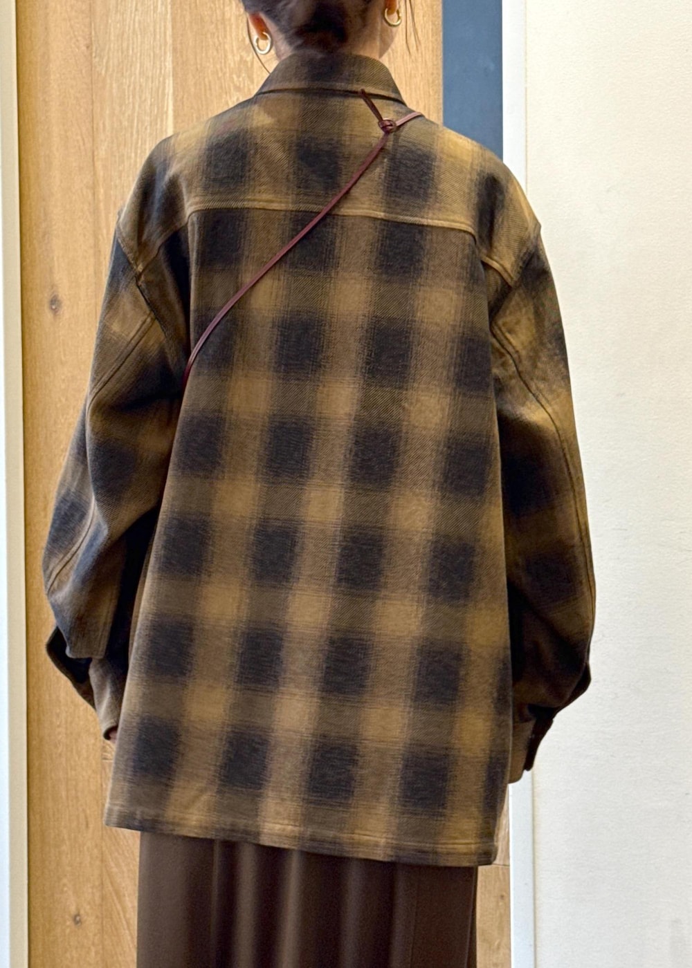 ブラック系のブーツ、ブラウン系のスカート、イエロー系のシャツ/ブラウスを着用したレディースの秋コーディネートの8枚目の写真